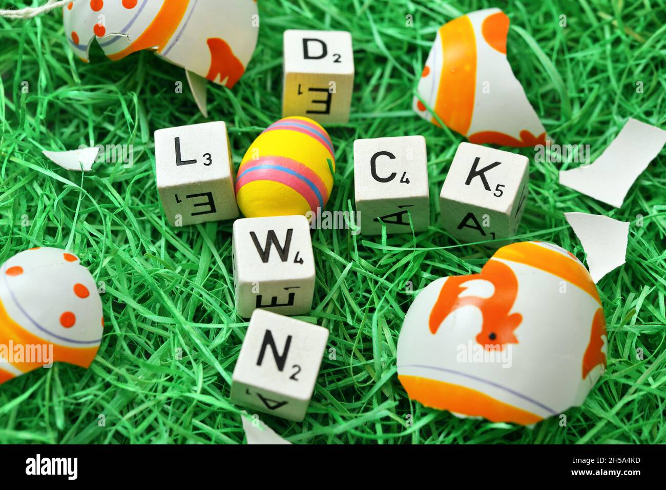 Buchstaben formen das Wort Lockdown in einem Osternest mit zerbrochenem Osterei, Symbolfoto harter Lockdown zu Ostern Foto Stock