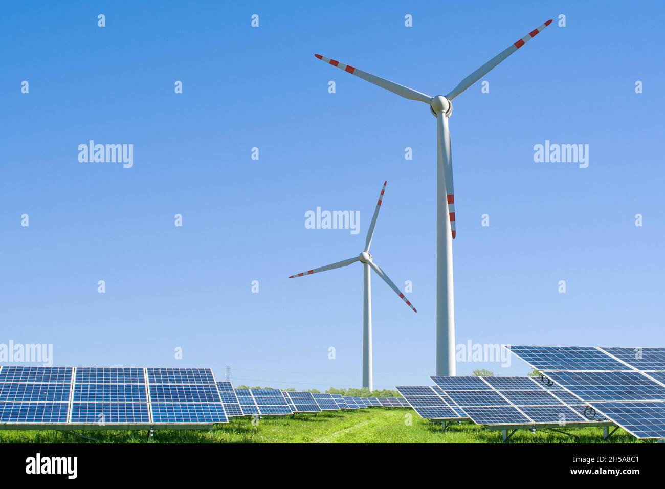 pannelli solari e turbine eoliche che generano energia elettrica a energia verde e rinnovabile centrale con cielo blu sfondo Foto Stock
