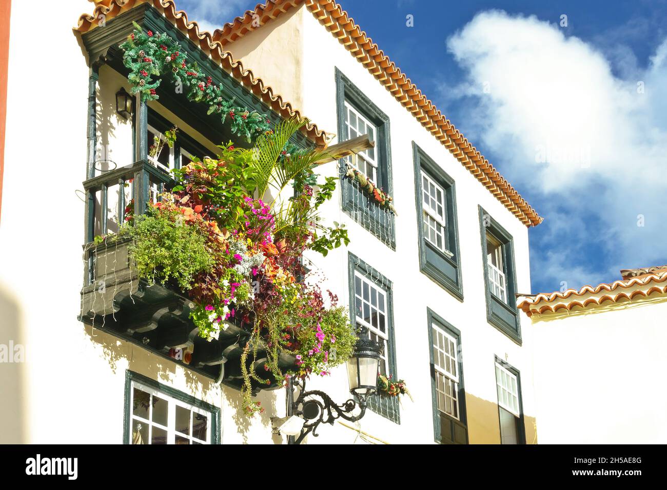 Vecchia casa con balcone in legno verde e un sacco di piante, fiori e decorazioni natalizie a Santa Cruz de la Palma, Isole Canarie. Foto Stock