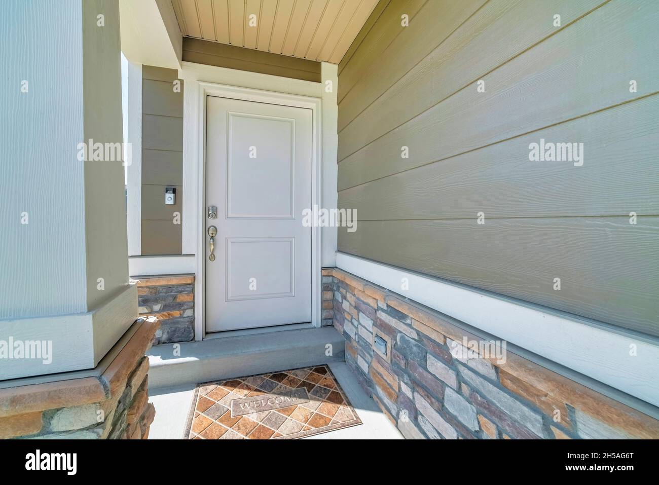 Ingresso interno esterno con porta bianca e tappetino Foto Stock