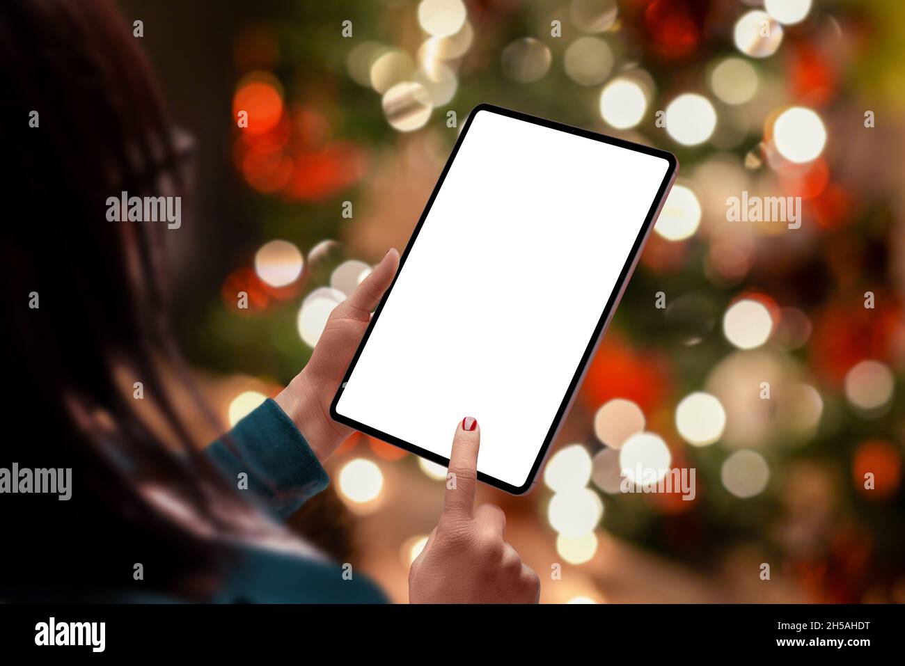 Tablet mockup in donna con un sacco di Natale bokeh luci sullo sfondo. Display isolato per la promozione dei contenuti Foto Stock