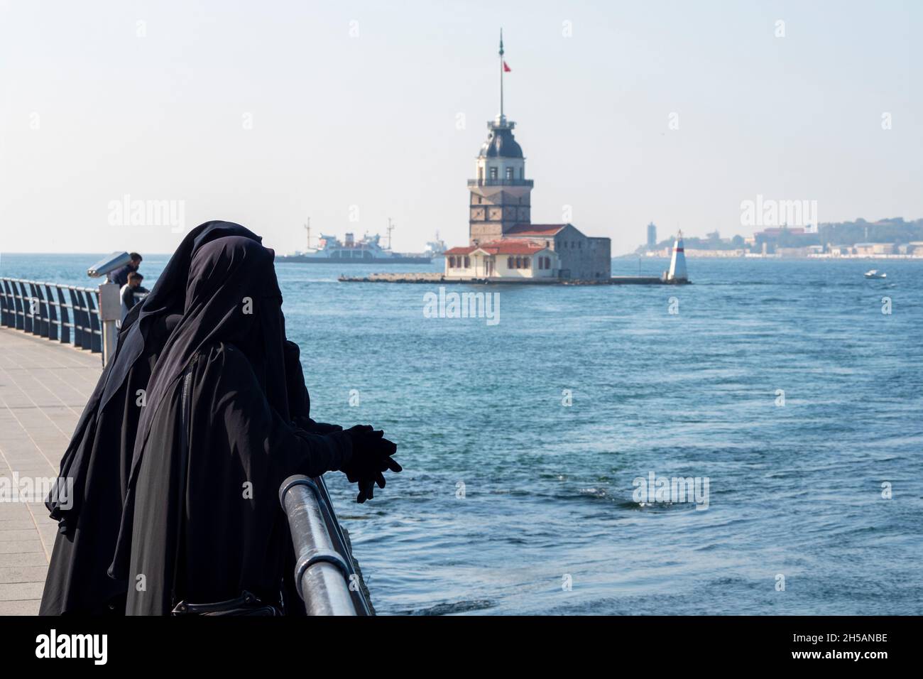 Due donne vestite in abiti musulmani tradizionali hijab nero, burqa e camminare al terrapieno di Istanbul, Turchia Foto Stock