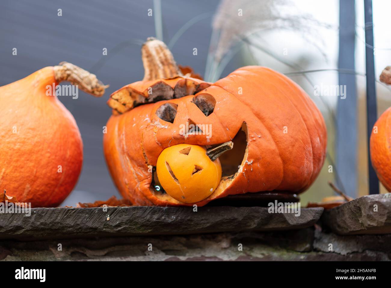 Una zucca di Halloween grande ha una zucca di Halloween più piccola nella relativa bocca. Foto Stock
