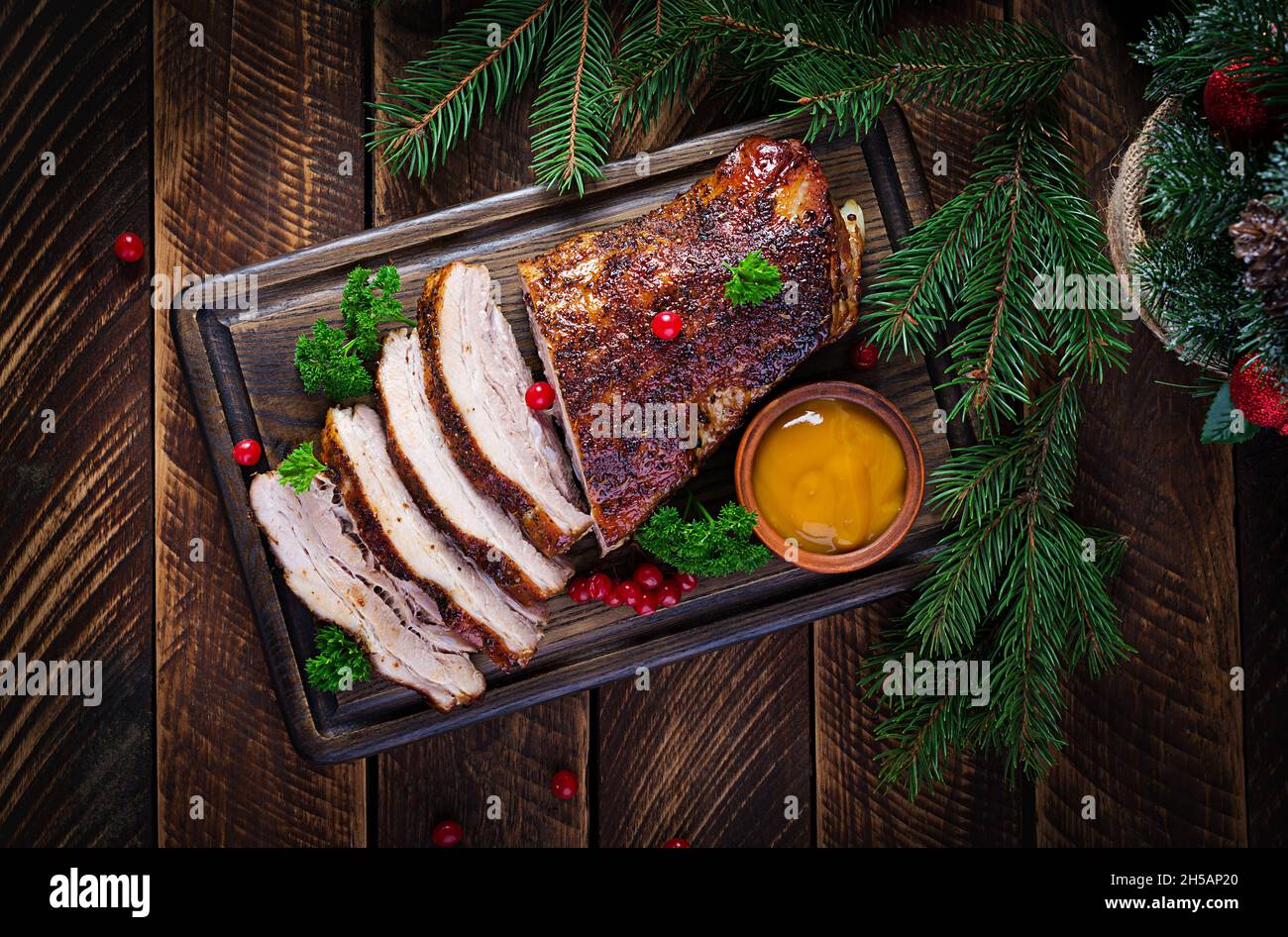 Pancia di maiale al forno con erbe aromatiche. Maiale bollito. Tavolo natalizio. Vista dall'alto, dall'alto Foto Stock