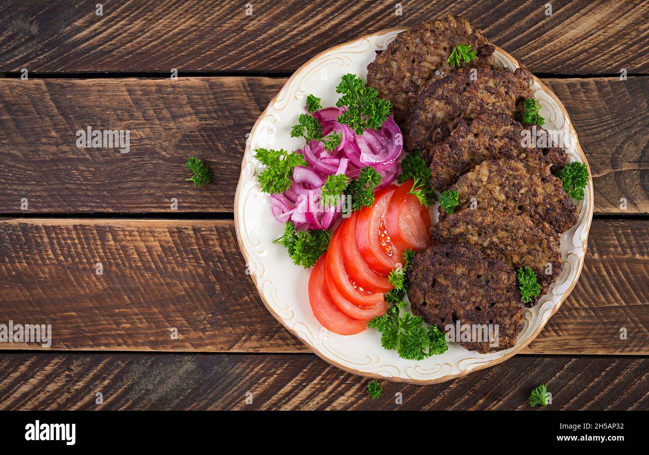 Frittelle di fegato di pollo con verdure su sfondo di legno. Frittelle di fegato di pollo fritto idea. Stile rustico. Vista dall'alto Foto Stock