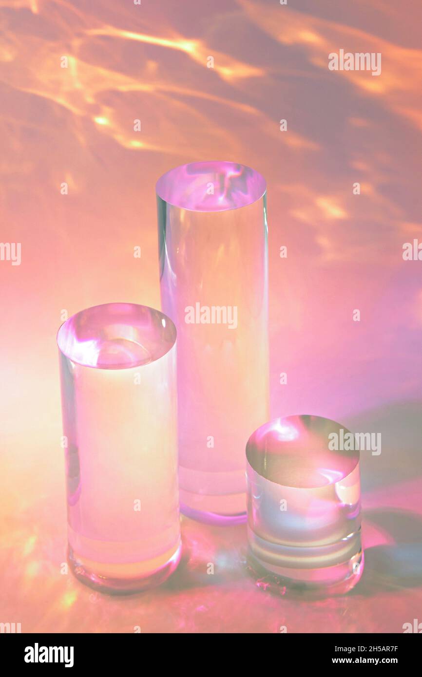 tre podi in vetro chiaro su sfondo rosa pastello Foto Stock