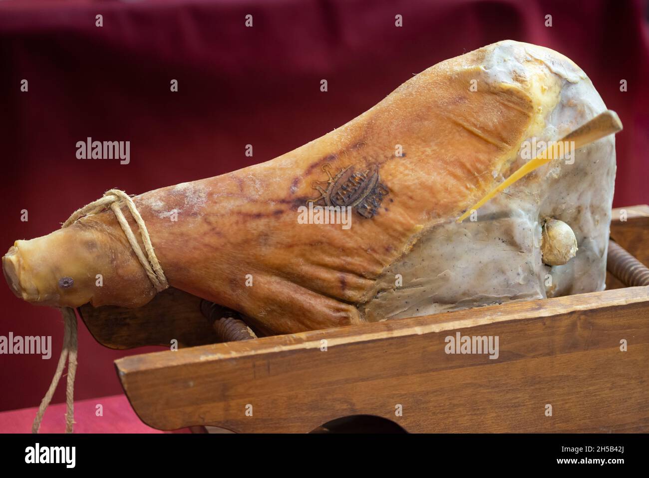 Intera gamba di Prosciutto di Parma in legno supporto, Fibula l'osso del cavallo utilizzato per la ricerca di salumi Foto Stock