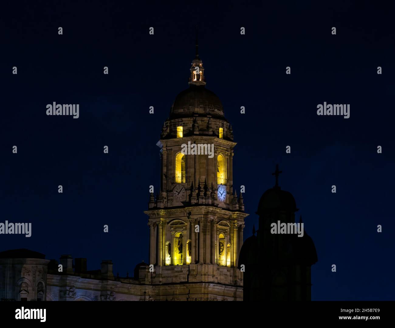 Campanile della Basilica Cattedrale illuminata di notte nel buio, Malaga, Andalusia, Spagna Foto Stock