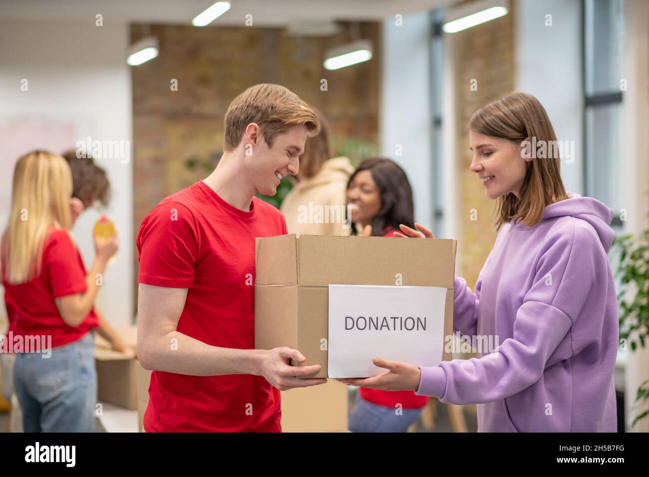 Volontari che lavorano in un centro di distribuzione delle donazioni Foto Stock