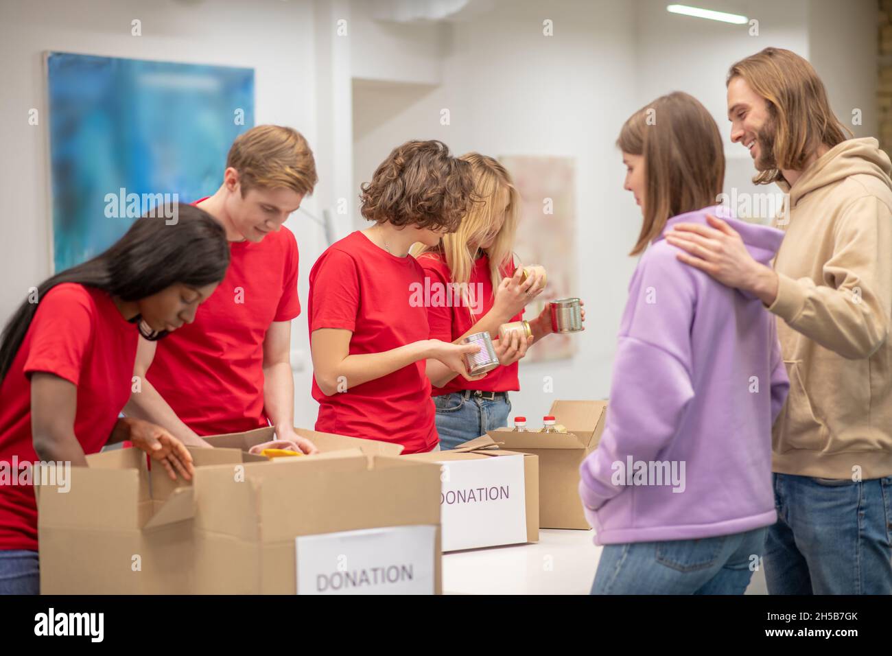 Volontari che lavorano in un centro di distribuzione delle donazioni Foto Stock