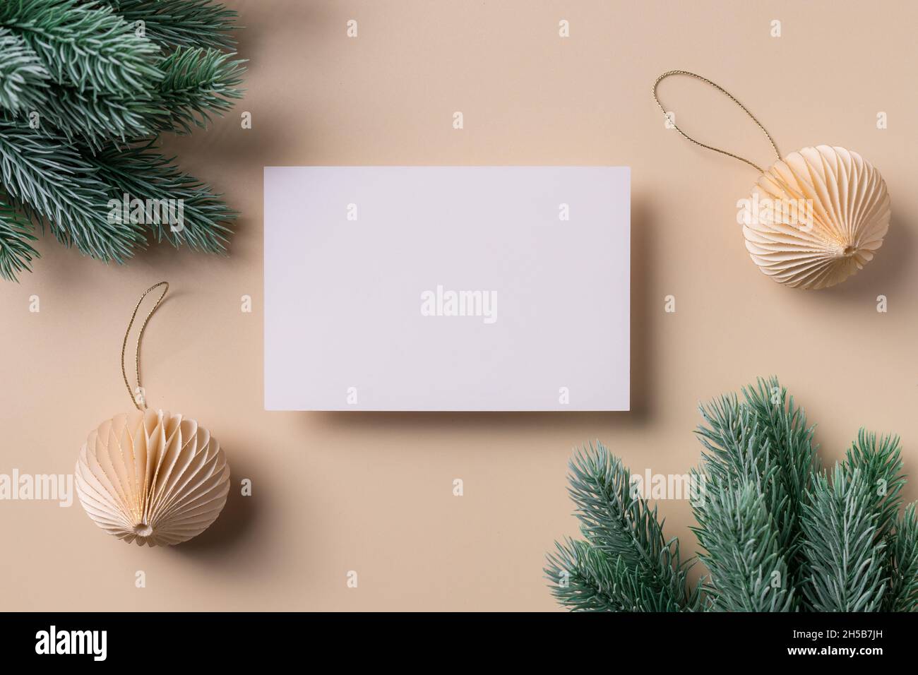 Scena mockup biglietto d'auguri con carta bianca e decorazioni natalizie Foto Stock