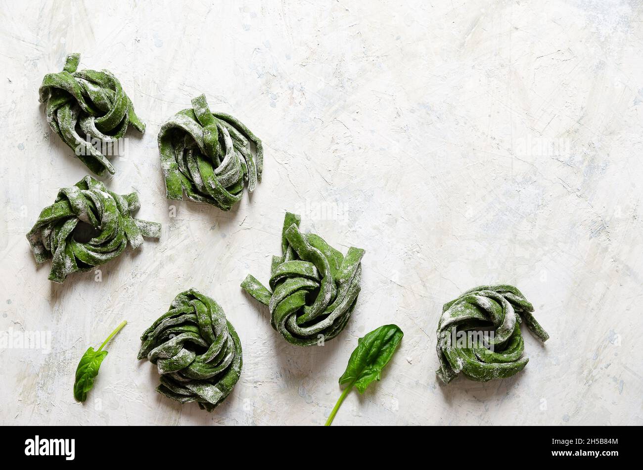 Spinaci fettuccine su uno sfondo chiaro. Foto Stock