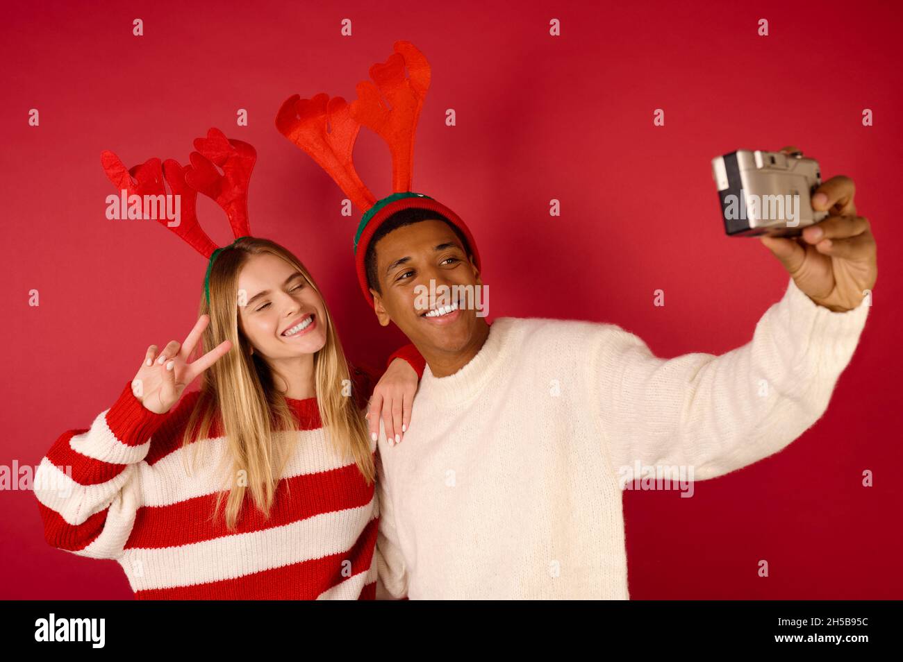 Una giovane coppia felice in cappelli cornati facendo selfie Foto Stock