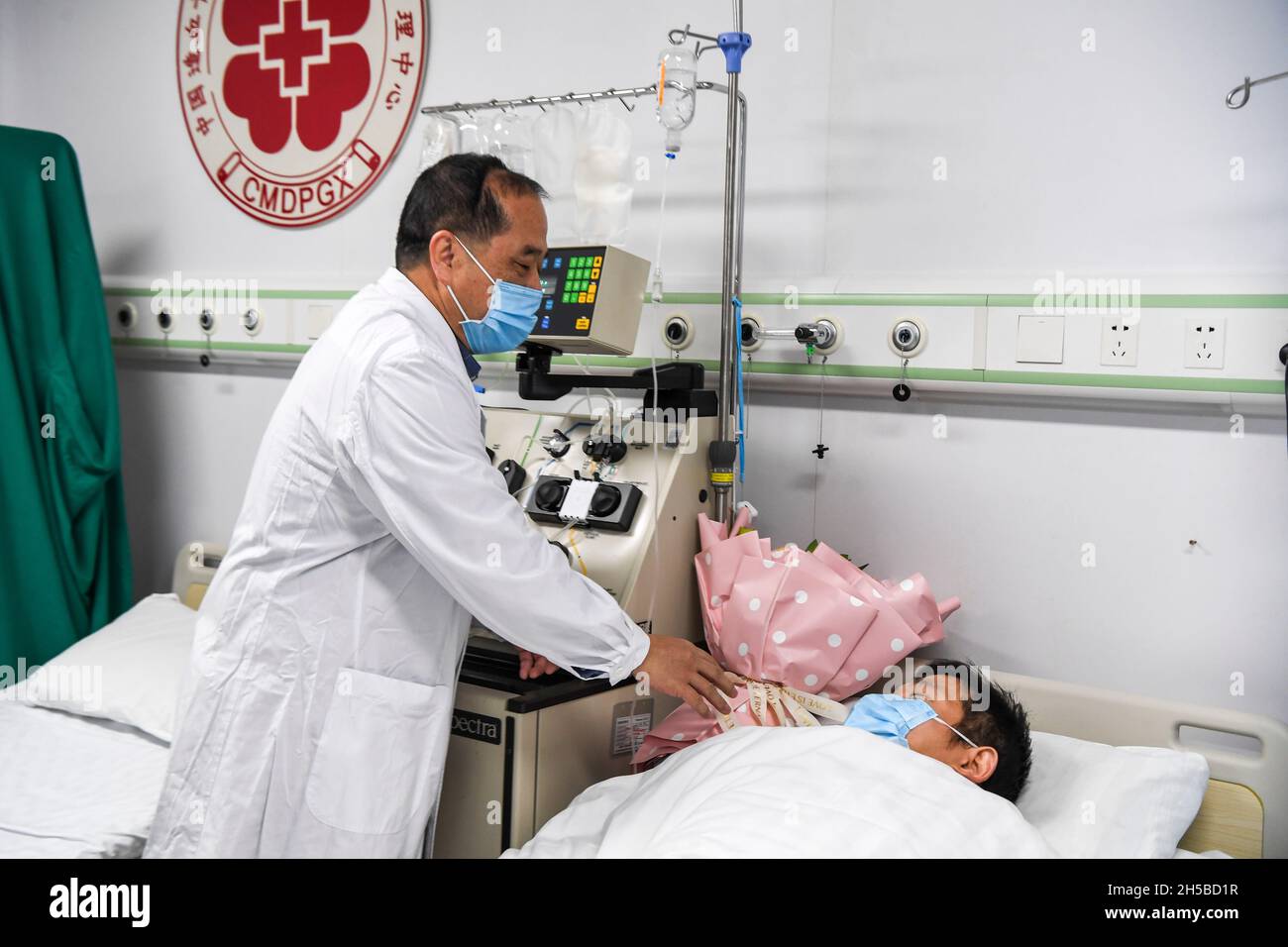 (211108) -- NANNING, 8 novembre 2021 (Xinhua) -- Un collega visita il medico li al primo ospedale affiliato della Guangxi Medical University a Nanning, nella regione autonoma di Guangxi Zhuang della Cina meridionale nel novembre del 2021. Li, un medico del reparto di ematologia del primo ospedale affiliato della Guangxi Medical University, registrato con il programma donatore di Marrow Cina (CMDP) come potenziali donatori di cellule staminali ematopoietiche (HSC) nel novembre del 2011. Come medico che fornisce trattamenti ematopoietici delle cellule staminali per i pazienti, egli abbina con successo un paziente come donatore di HSC nell'agosto del 2021. Li donare Foto Stock