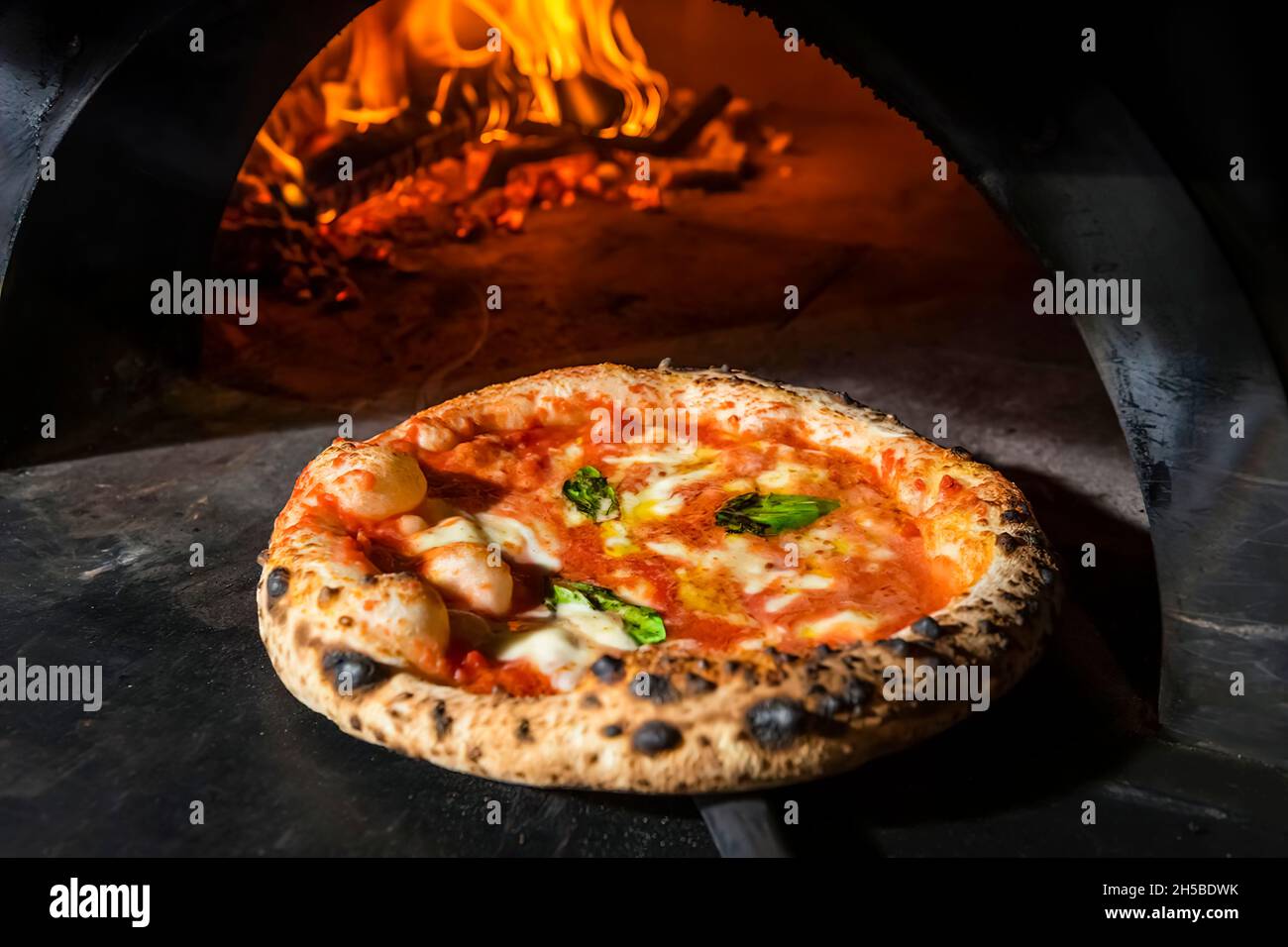 Una pizza margarita direttamente da un forno a legna. Primo piano, cotto in  forno a legna per pizza. Cucina italiana Foto stock - Alamy