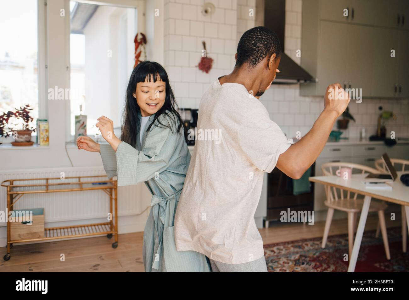 Gioiosa amica femminile e maschile che balla a casa Foto Stock