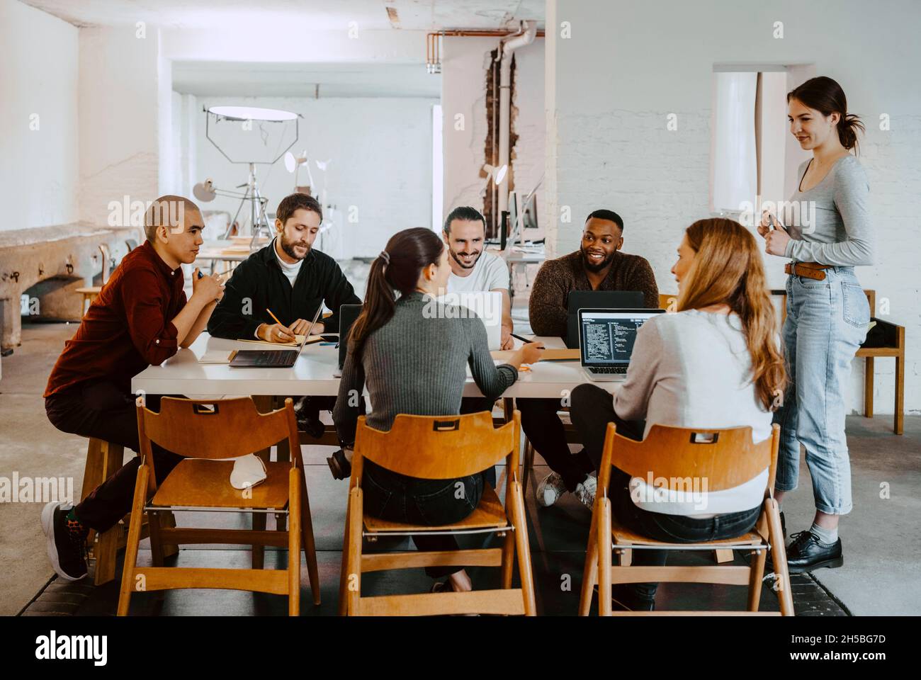Sorridenti uomini d'affari e uomini d'affari in riunione alla startup Company Foto Stock