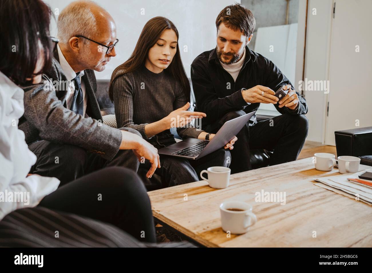 Hacker femminile che discute su un notebook con il consiglio di amministrazione di startup Company Foto Stock