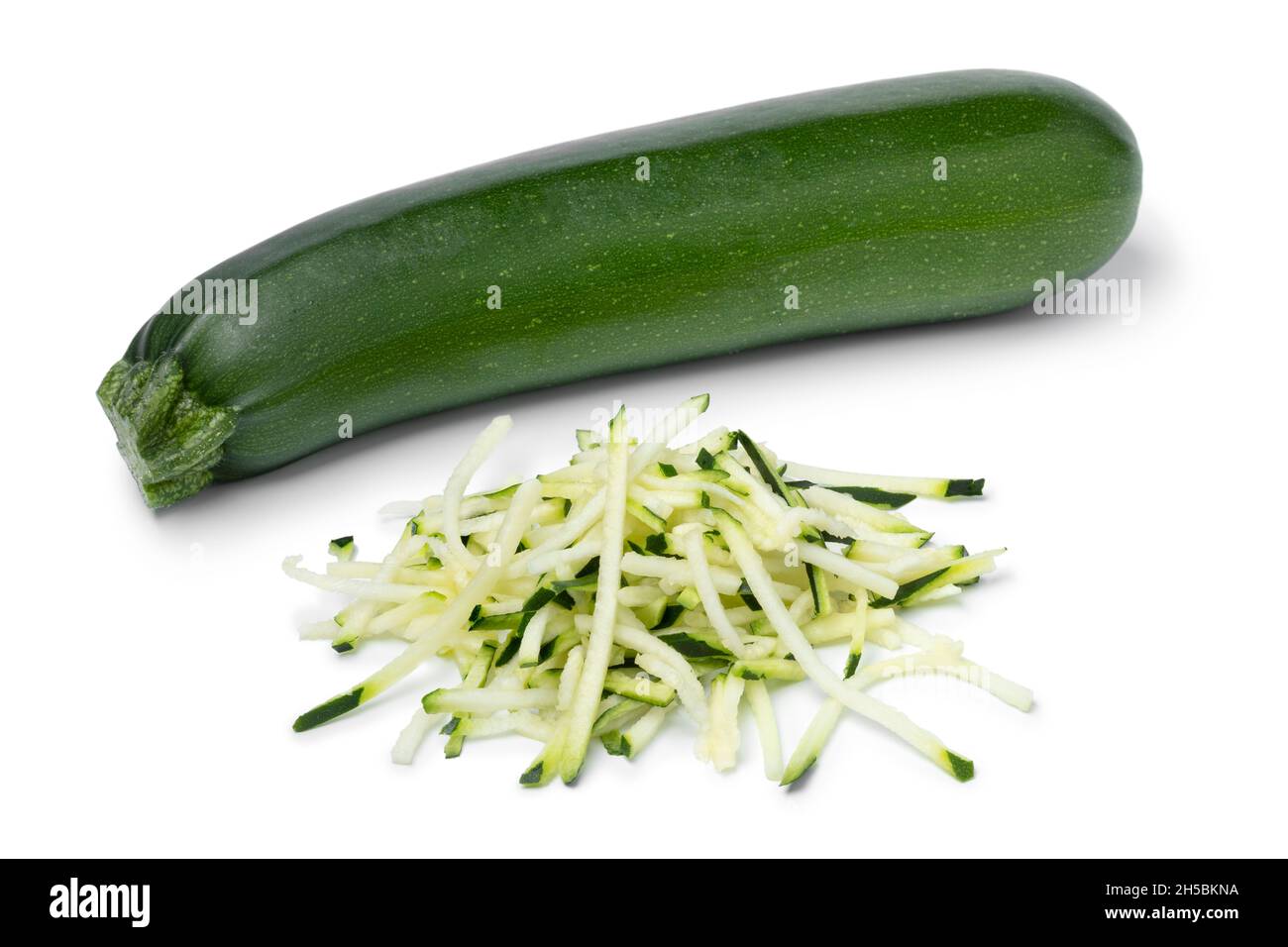 Singolo zucchine fresche verdi intere e un mucchio di spaghetti isolati su  sfondo bianco Foto stock - Alamy