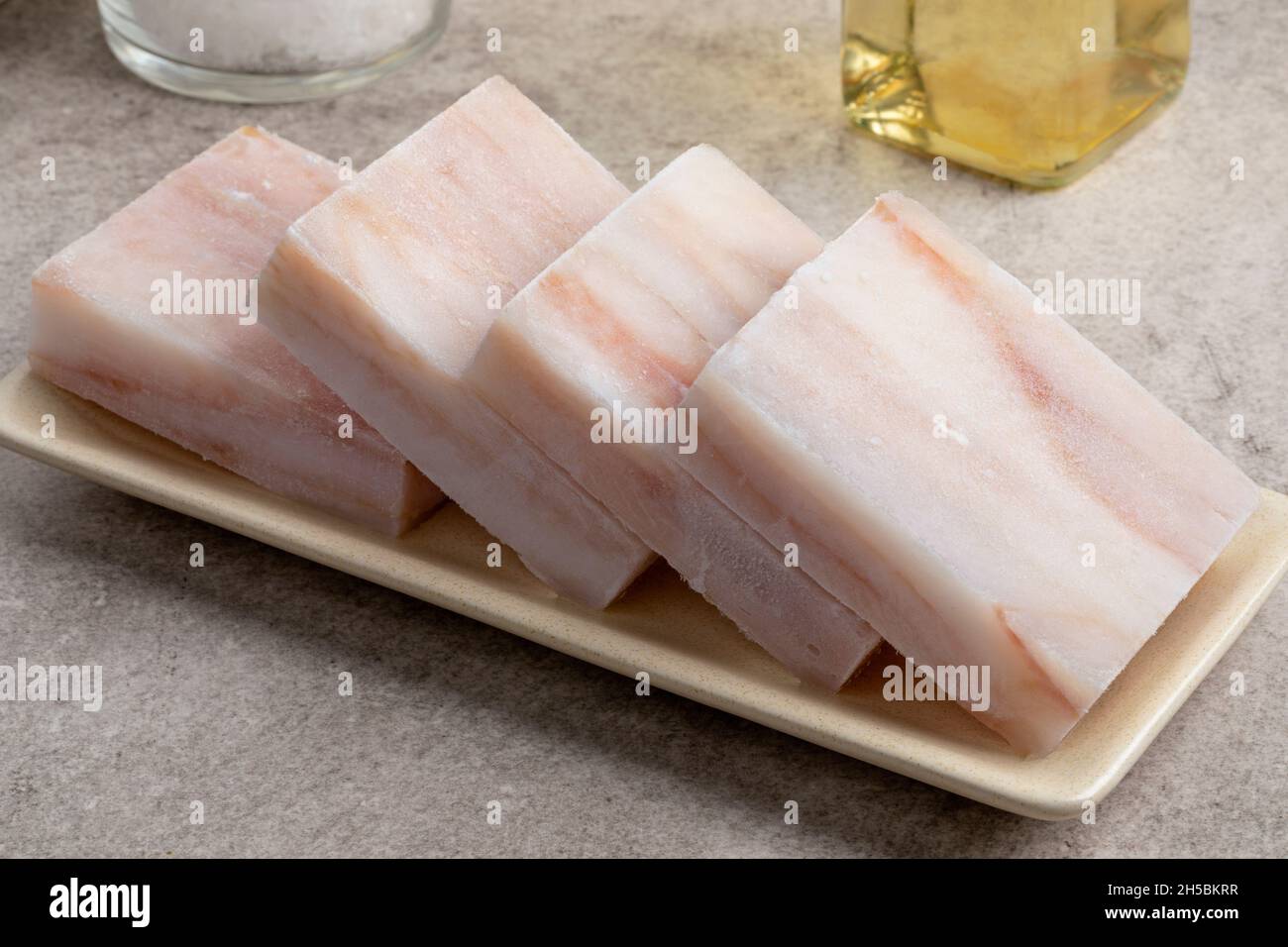 Piatto con filetti di pesce di pollock congelati da scongelare come ingrediente per la cottura Foto Stock