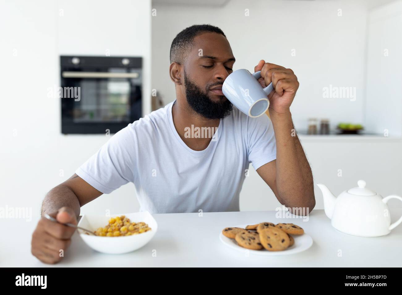 Uomo nero che soffre di insonnia bere caffè Foto Stock