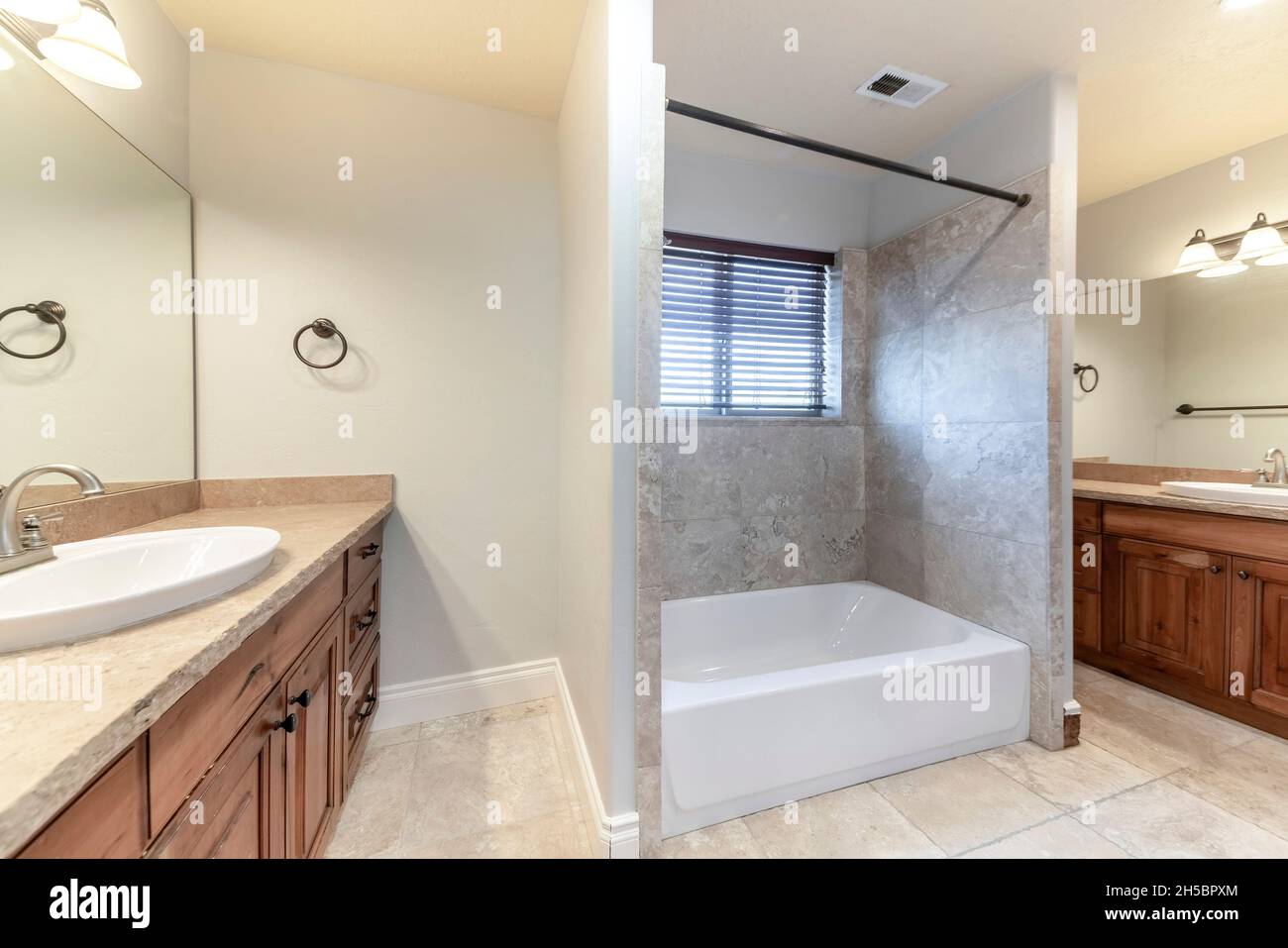 Bagno principale con vasca nel mezzo di due lavandini Foto Stock