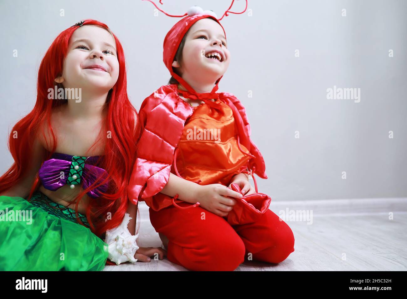 Bambini in eleganti costumi di carnevale su uno sfondo semplice. Costume di  creature fata di mare. Sirena e granchio. Fratello e sorella Foto stock -  Alamy