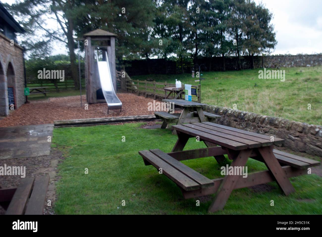 Posto a sedere e tavolo sul retro del Visitor Center presso Housesteads Roman Fort, vicino a Hexham, Northumbria, Inghilterra, Regno Unito Foto Stock