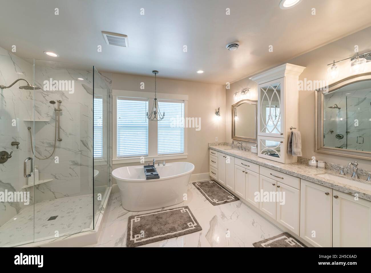 Lussuoso bagno principale con piastrelle in marmo e finestra Foto Stock