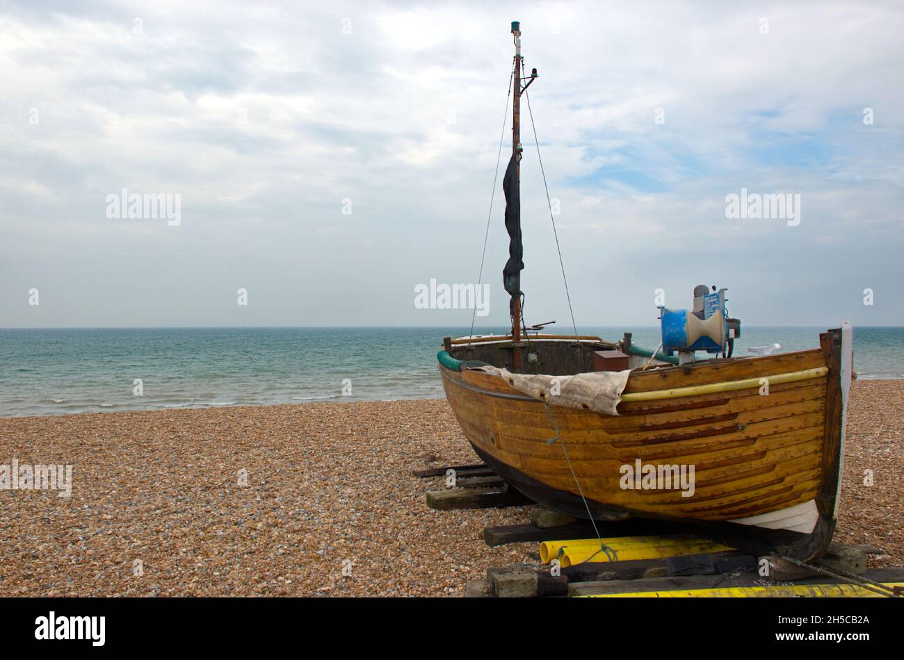 Una piccola barca da pesca lanciata sulla spiaggia su ghiaia a Bulverhythe, Sussex, Inghilterra, Regno Unito. Foto Stock