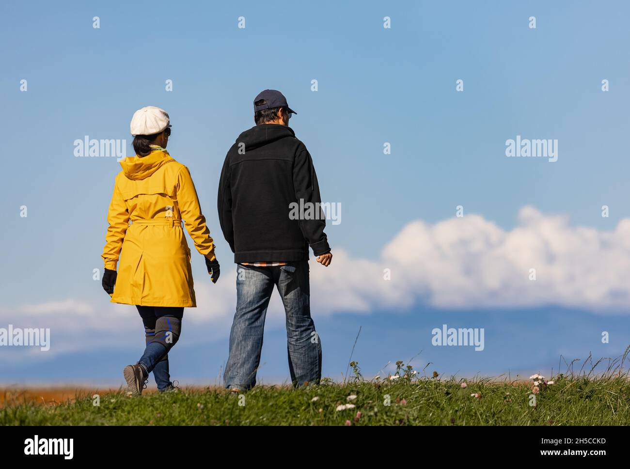 Coppia a piedi nel parco in autunno soleggiato giorno. Uomo e donna che camminano all'aperto in freddo giorno d'autunno. Street view, foto di viaggio, spazio per la copia del testo. Foto Stock