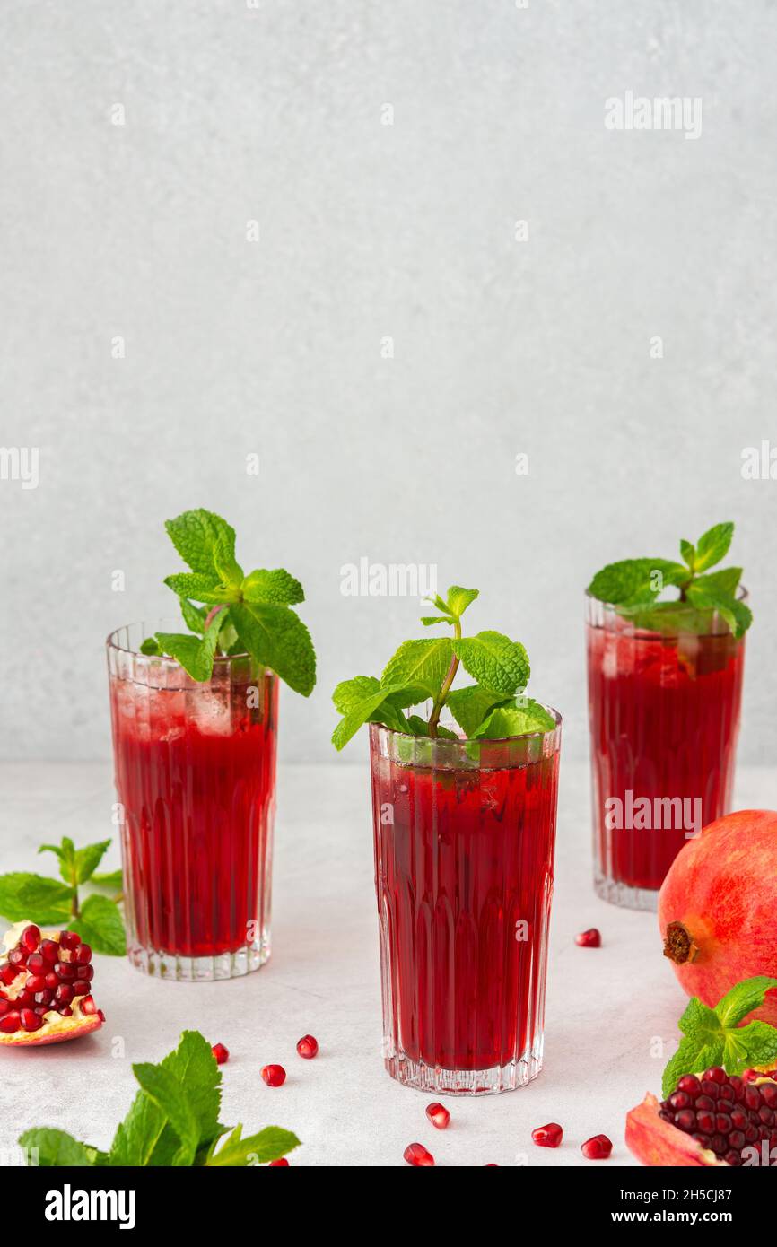 Rinfrescante succo di melograno in bicchieri con menta e ghiaccio, bevanda fredda Foto Stock