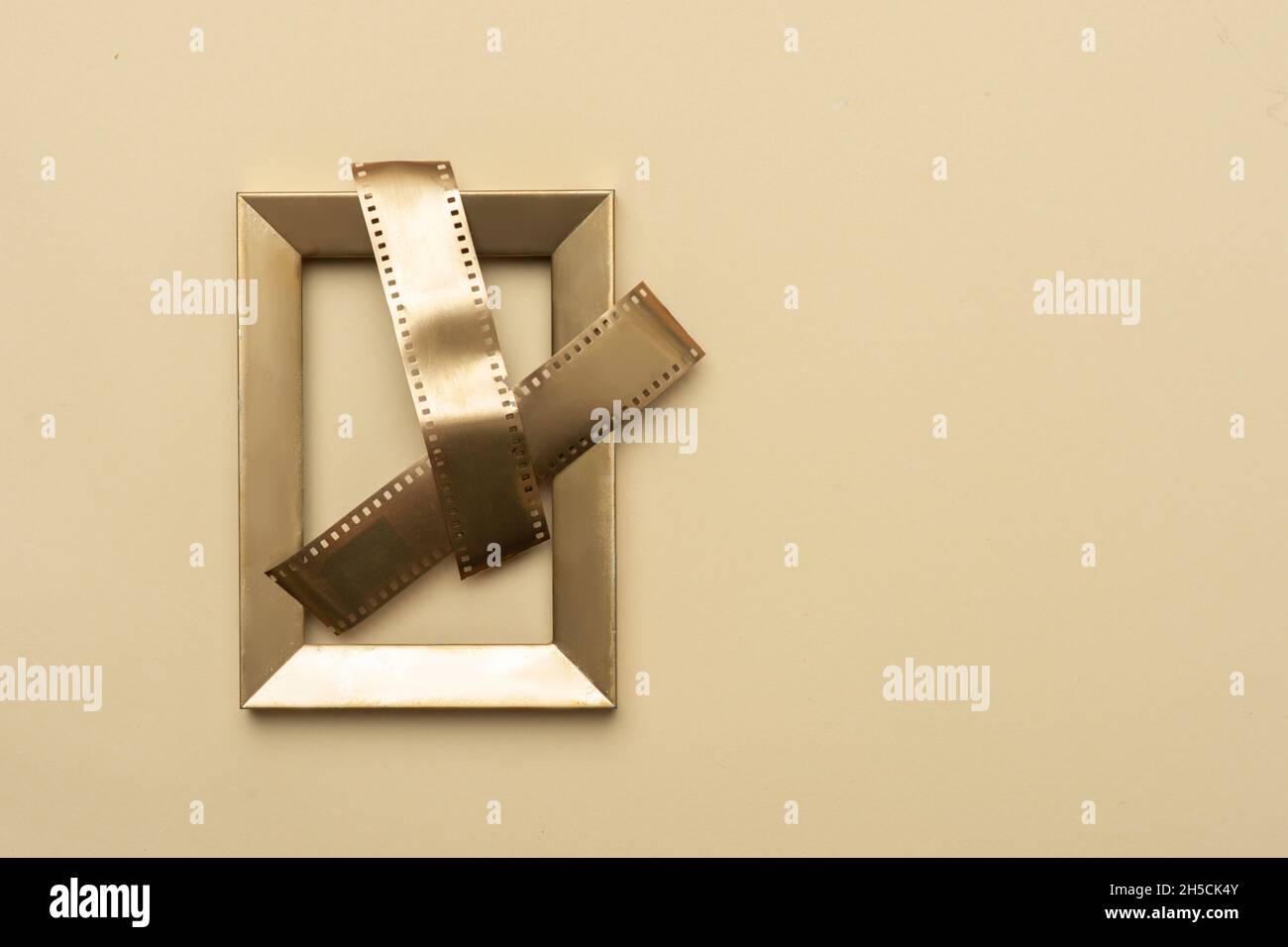 Strisce di film in oro su telaio in oro su sfondo beige. Poster a tema multimediale orizzontale, biglietti d'auguri, intestazioni, sito Web e app Foto Stock