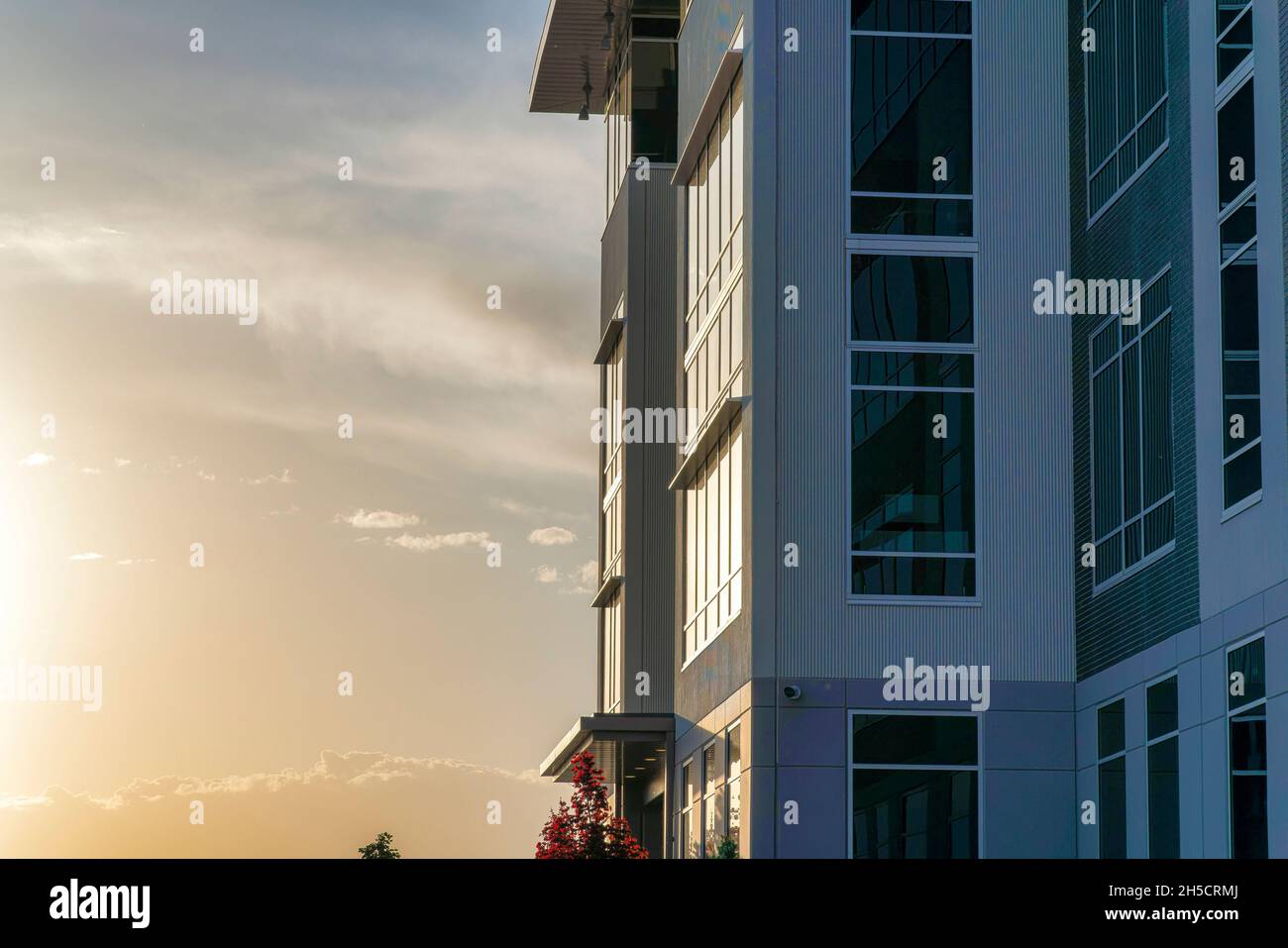Il tramonto si riflette sulle pareti di vetro dell'edificio Foto Stock