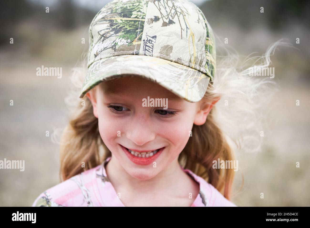 Bambina con cappellino Camo e camicia rosa, Petting Longhorn Cattle in Texas Foto Stock