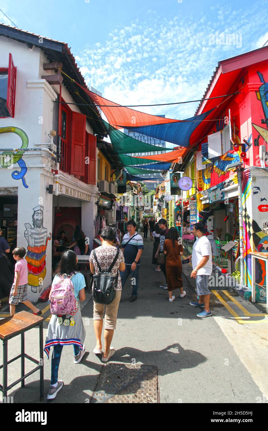 Caffè, bar e negozi con molti visitatori a piedi nella strada in Haji Lane nel quartiere Kampong Glam di Singapore. Foto Stock