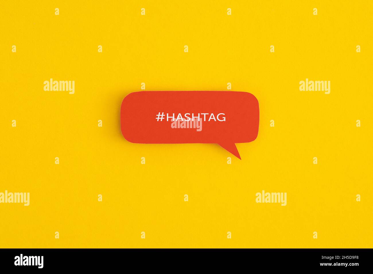 Fumetto cartaceo con la parola '#Hashtag' su sfondo giallo. Vista dall'alto con spazio di copia. Disposizione piatta. Foto Stock