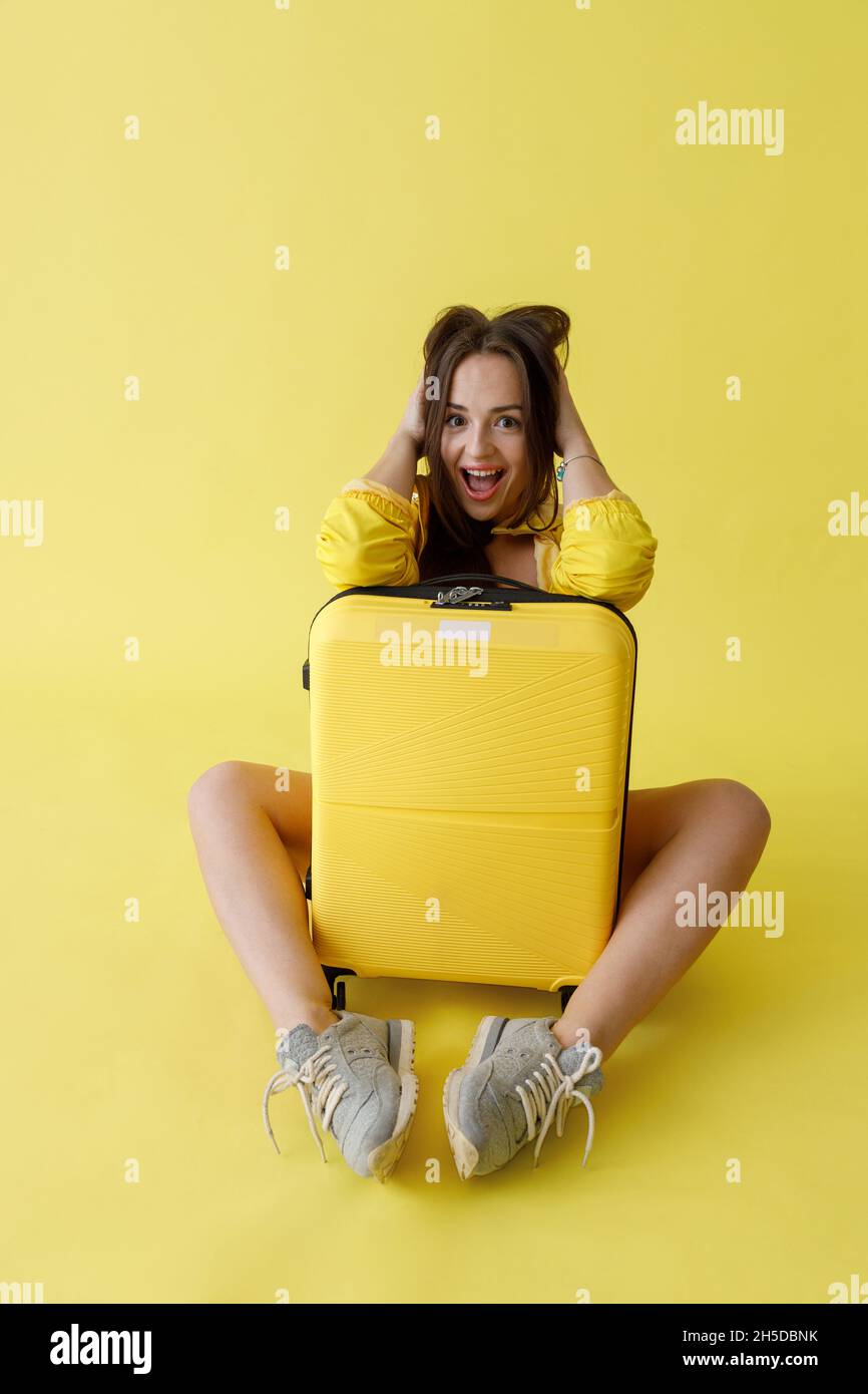 Donna gioiosa con borsa carrello in posa in studio Foto Stock