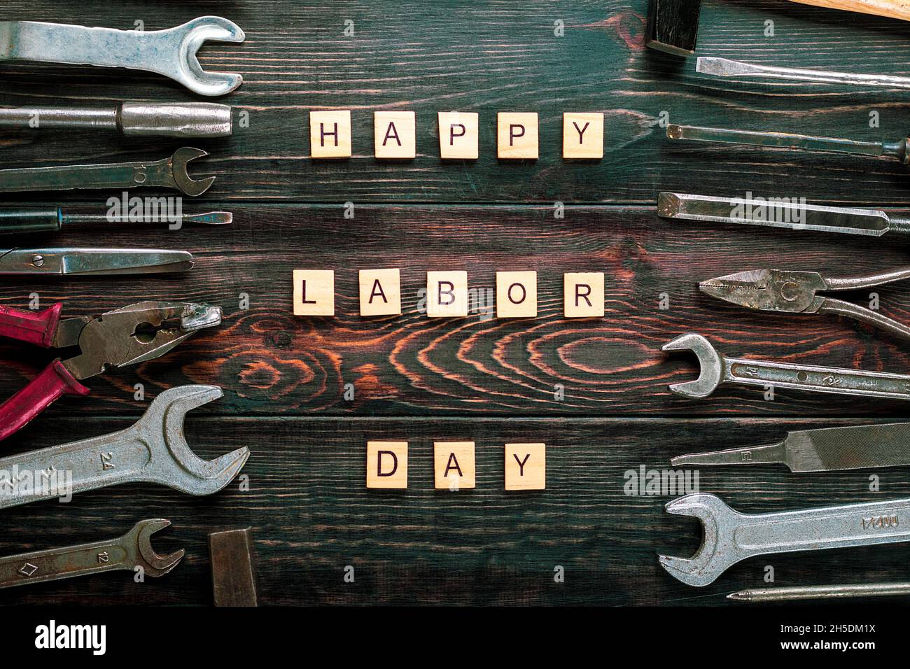 Happy Labor Day concept Construction group home tools - martello, sega, cacciavite, misuratore, pinze, chiave, scalpello su sfondo blu legno scheda vacanza Foto Stock