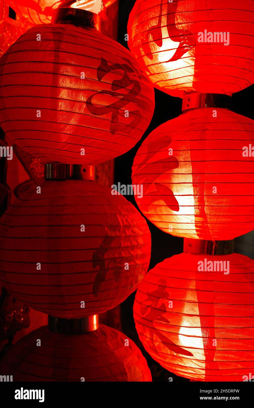 Lampada a palloncino di carta rossa cinese con lettere cinesi che significano il ristorante del tè e la luce luminosa che si illumina nella notte buia. Foto Stock