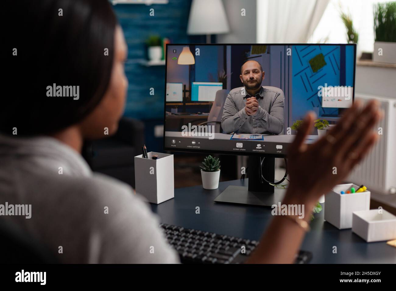 Donna che sventolano la mano alla videochiamata webcam con il manager, utilizzando la videoconferenza online per parlare di progetto di business. Dipendente che utilizza il computer per una riunione remota con l'uomo, lavorando da casa Foto Stock