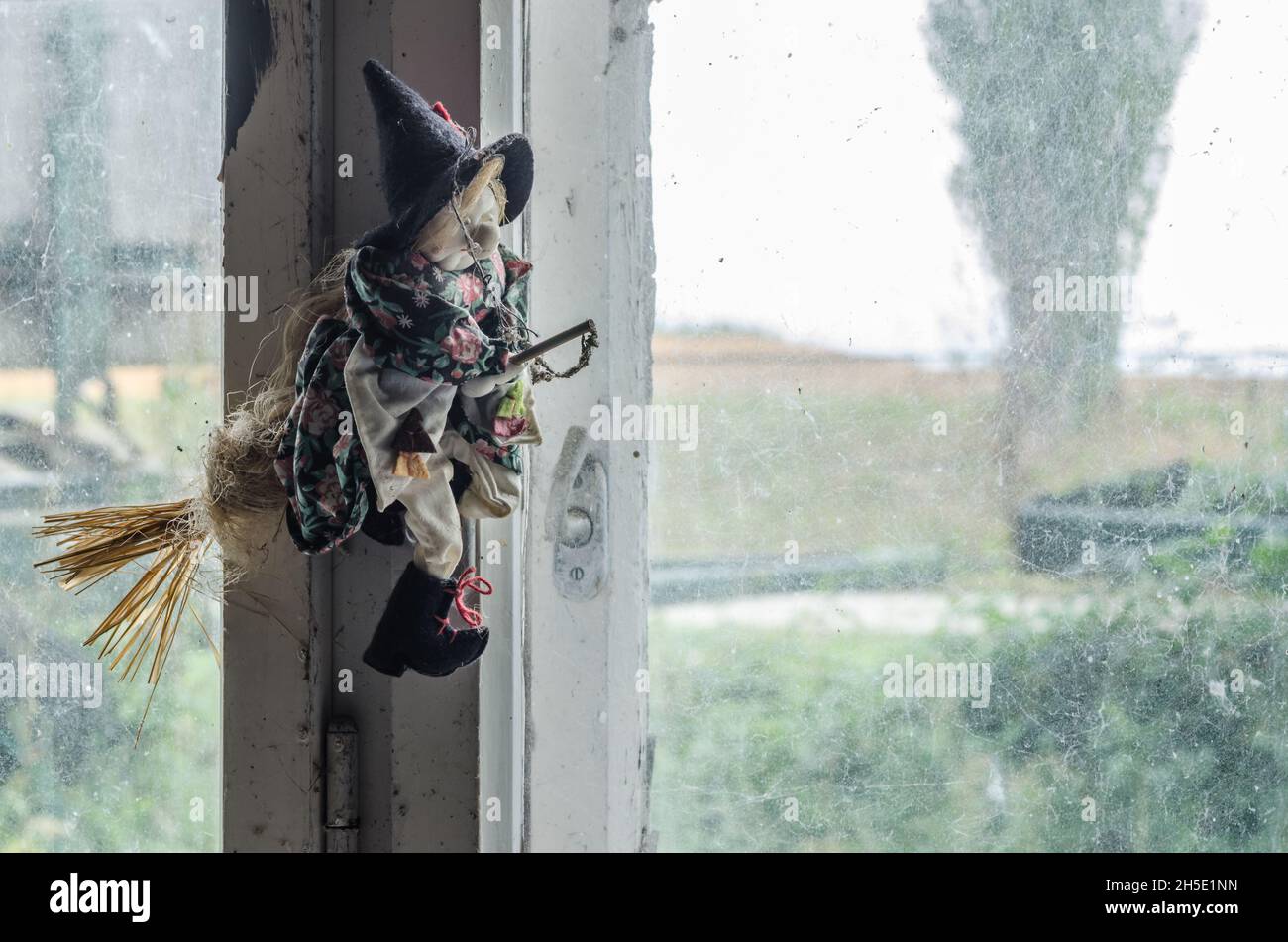 bambola strega alla finestra nella vecchia casa Foto Stock