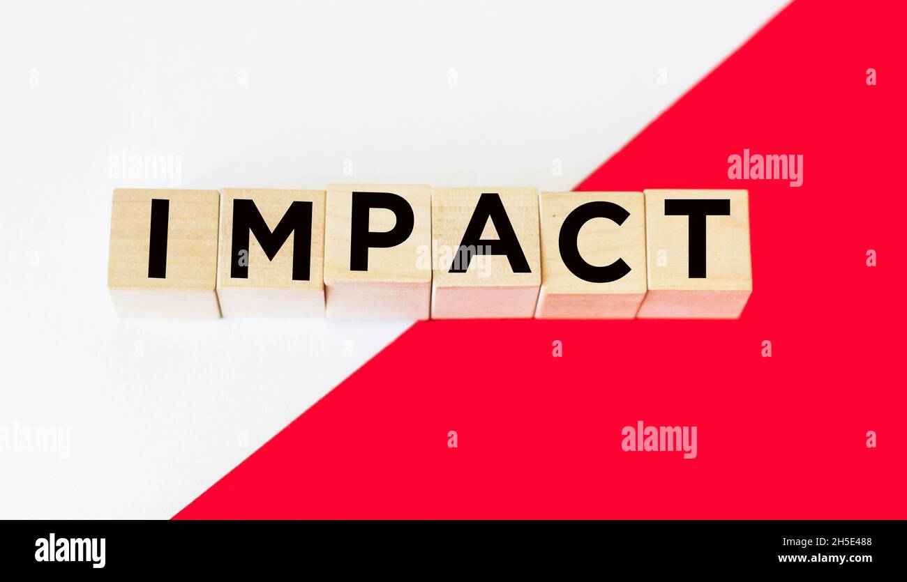 impatto - è un nome fatto di lettere di legno. Su sfondo rosso e bianco. Informazioni e comunicazioni. Foto Stock