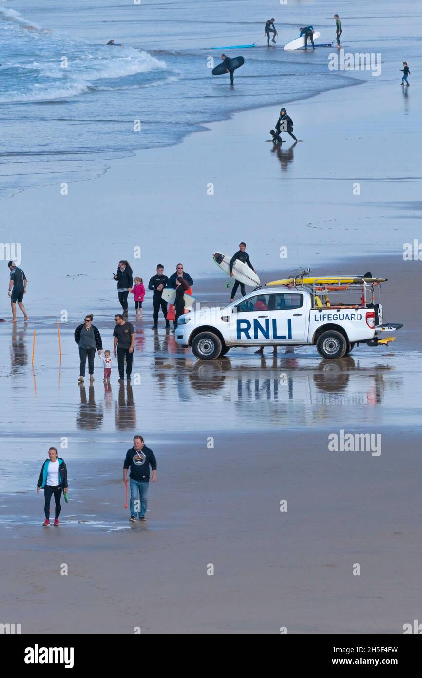 Un veicolo di emergenza RNLI e villeggianti sulla spiaggia a Fistral a Newquay in Cornovaglia. Foto Stock