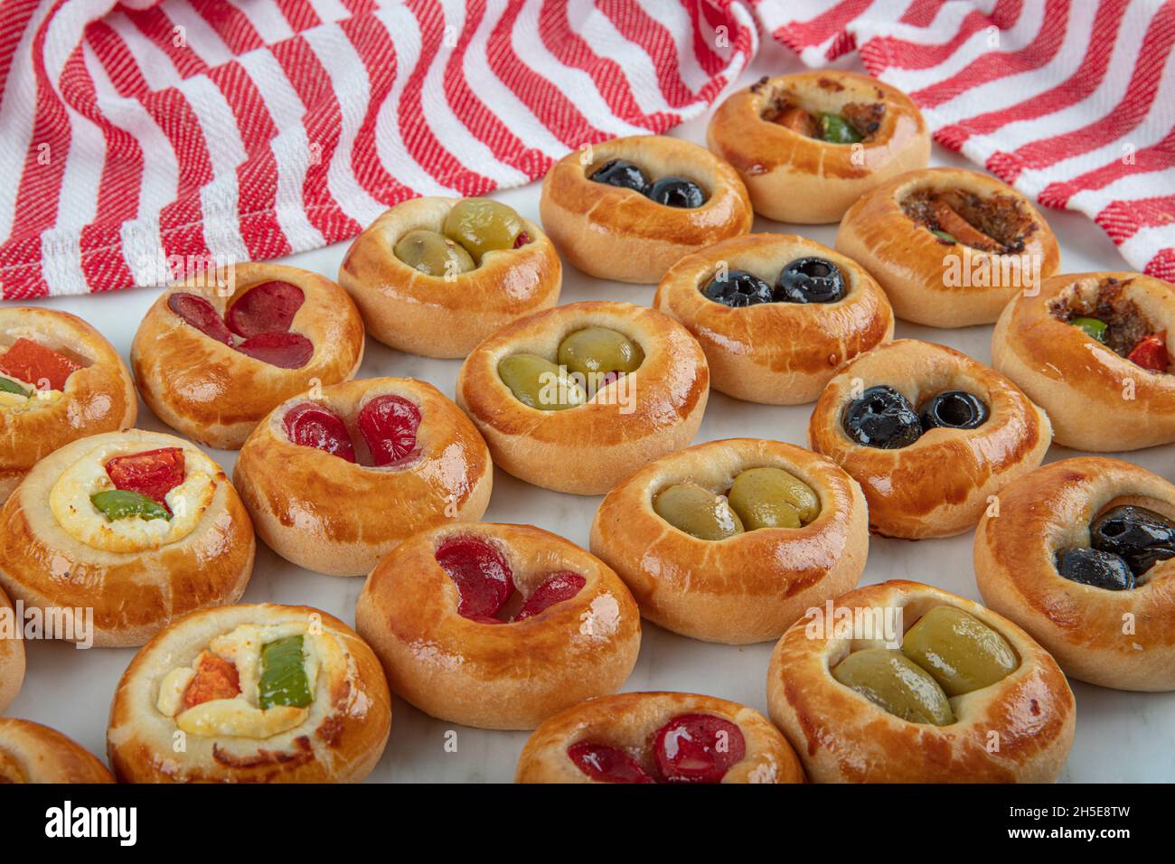 Mini Hot Dogs servito come buffet aperto. Mini pizze con verdure assortite, mozzarella e basilico fresco su sfondo marmoreo, primo piano, vista dall'alto. Foto Stock