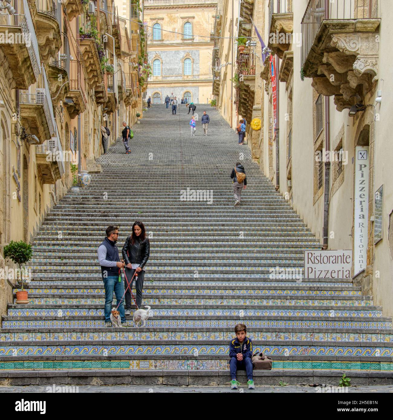 Caltagirone , Sicilia, Italia - 10 ottobre 2015: Un ragazzino siede in fondo alla Scalinata di Santa Maria del Monte, famosa in tutto il mondo Foto Stock