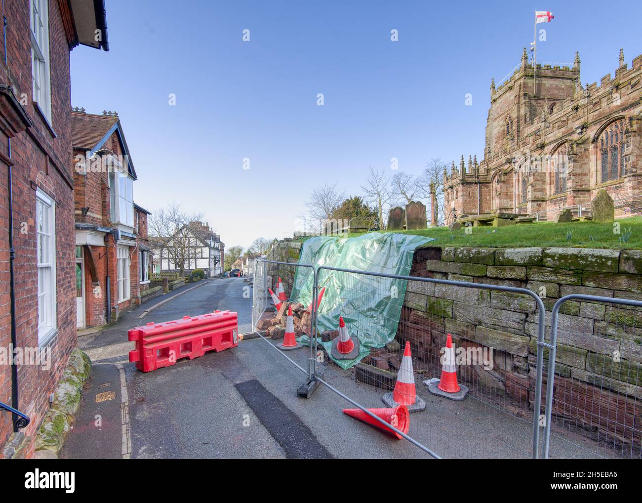 Malpas, Cheshire, Regno Unito - 18 febbraio 2021 : una vista del muro crollato dalla chiesa di St. Oswald, Church Street, Malpas. Il blocco stradale cau Foto Stock