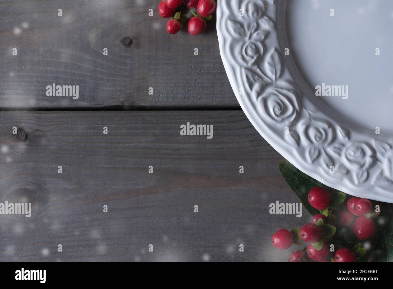 Piatto bianco per dolce dessert invernale decorato con fiocchi di neve e bacche rosse. Foto Stock