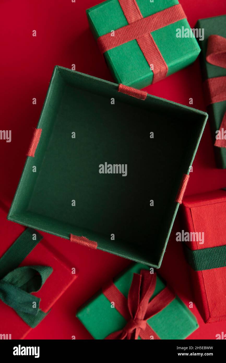 Aprire la casella regalo natalizio su sfondo rosso. Disposizione piatta, vista dall'alto Foto Stock