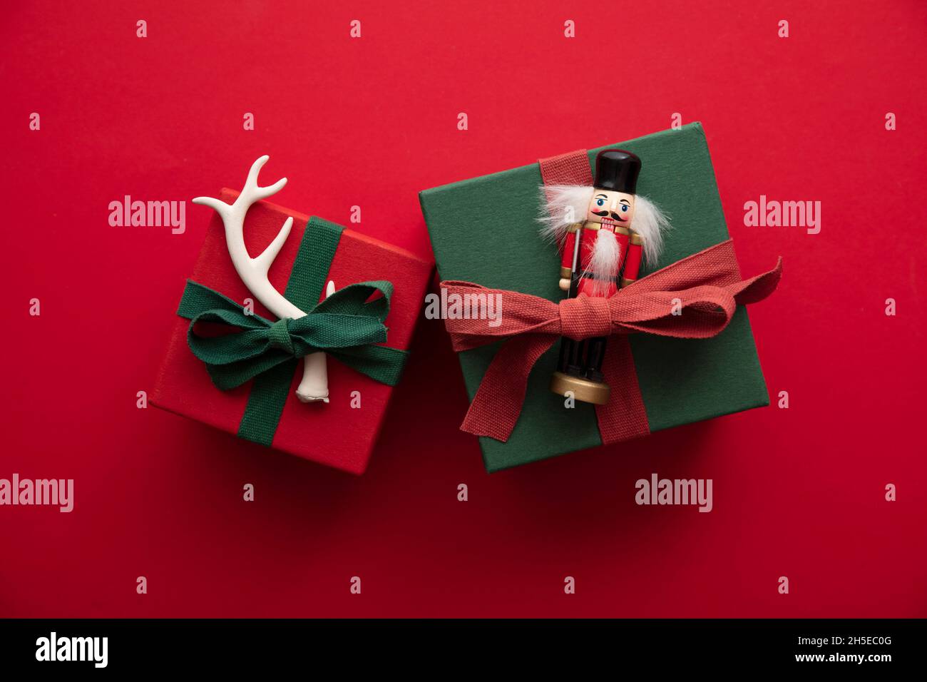 Elegante scatola regalo di Natale realizzata a mano con nastro rosso e una corna di renna festive e giocattolo Foto Stock